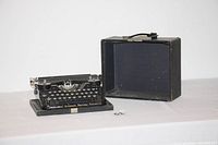 Overall view of the Underwood Standard Portable Typewriter with the black case open beside it, showing size and condition.