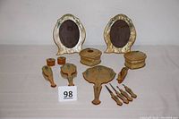 Full set arranged on white surface showing all pieces including frames, mirror, brushes, boxes, and tools with green jewel decoration.