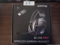 Photo of the closed retail box of Gikking BL100 Pro wireless gaming headset, showing the headset image, USB adapter, and branding.