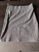 Grey Jed North stretchy spandex skirt laid flat on table showing front side and metal zipper detail on the side.