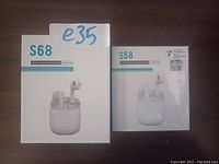 Photo of two unopened boxes of white true wireless earbuds, models S68 and S58, placed side by side on a flat surface.