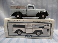 Die cast 1940 Ford Pickup truck coin bank with Delta advertising, mounted on the box showing side and front details.