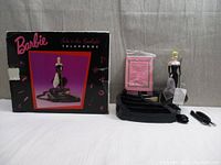 Photo showing the Barbie telephone with original box, certificate, telephone cords, and telephone base with Barbie figurine.