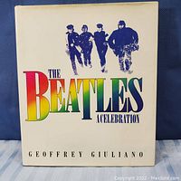 Front cover of the book 'The Beatles A Celebration' by Geoffrey Giuliano with colorful title and black and white photo of The Beatles.