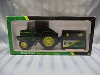 Front view of the vintage John Deere remote control tractor and trailer in original box with clear window.