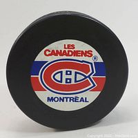 Image showing the Montreal Canadiens team logo printed on one flat side of the puck with red, white, and blue colors.