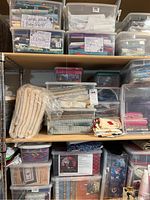 Multiple stacked plastic bins filled with various types of fabric labeled for baby quilts and flannels