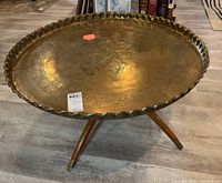 Oblique view of complete table showing scalloped brass top on wooden tripod base