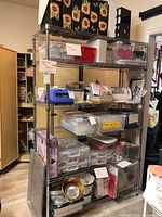 Front view of six-tier shelving unit loaded with various containers and craft supplies