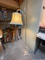 Full view of antique cast iron floor lamp with fabric shade showing the height and adjustable arm.