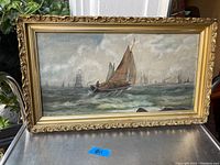Full view of the framed maritime oil painting on canvas, showing the sailboat and multiple ships in the background with cloudy sky and ocean waves.