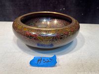 Side view of one solid brass cloisonné bowl showing detailed floral design and rounded shape