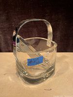 Front view of the Orrefors crystal ice bucket with metal handle and ice tongs inside