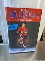 Front cover of the book showing Jean Beliveau in hockey uniform with the title and author's name.