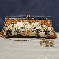 Full view of agate and glass beaded evening handbag purse with floral patterns, a metal frame, and gold-tone chain strap, plus a small bag of metal parts