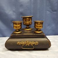 Full view of antique leather desk organizer with three brass candle holders on top, showing the item's overall condition and design.