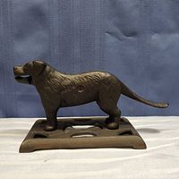 Side profile photo of the brown cast metal St Bernard dog standing on a flat base, showing full length and base design.