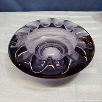 Top angled view of the amethyst glass dish or ashtray showing the large dips on the rim and smooth reflective surface.