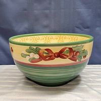 Full view of the Christmas themed ceramic serving bowl, showing the holly, mistletoe, and red ribbon decoration around the bowl.