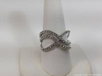 Front view of size 10 sterling silver infinity ring showing the cubic zirconia stones set in two intertwined bands.