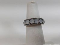 Front view of sterling silver ring size 5 with seven round opal stones inlaid on band.
