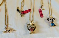 Four Betsy Johnson pendant necklaces laid out to show each pendant in detail.