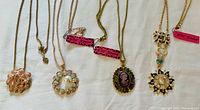 Five Betsey Johnson pendant necklaces displayed flat on a white background, showing each necklace's pendant and chain details.