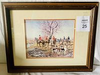 Framed print showing a hunt scene with riders and hunting dogs, matted and under glass in a wooden frame.