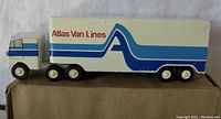 Side view of the Atlas Van Lines tractor and trailer model showing the full length of the item on a beige surface.