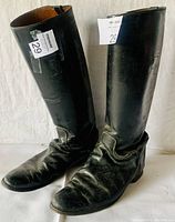 Front view of the black leather riding boots showing creasing and scuffs on the leather.
