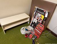 Wide view showing white shoe shelf, folded card table, boxed closet organizer, and miscellaneous locks on floor