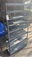 Full front view of the metal shelf unit showing all seven shelves and the metal frame in natural light.