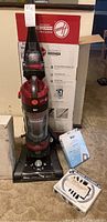 Full view of Hoover vacuum cleaner with box and accessories including filter replacement and service kit.