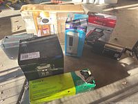 Overview of boxed espresso maker, breakfast station, Sony antenna, radio, fan and inflator