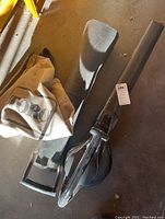 Photo showing Toro blower vac parts including nozzle, handle, and collection bag on garage floor.