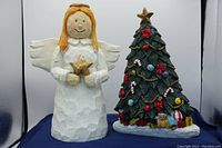 Wooden angel and Christmas tree holiday figurines with detailed decorations and paint.