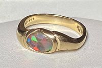 Front view of the 10K gold ring with an oval opal quartz crystal stone showing colorful flashes.