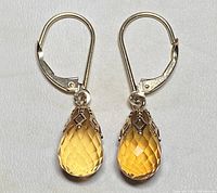 Front view of both earrings showing faceted yellow topaz briolette drops and lever-back closures