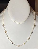 Full necklace displayed on white bust showing alternating cultured pearls and bezel-set colored gemstones on a fine gold chain