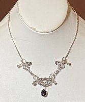 Front view of the vintage sterling silver filigree necklace with black cabochon pendant displayed on bust form.