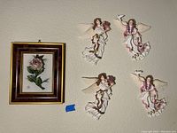 Framed Capodimonte porcelain rose artwork and four porcelain angel wall hangings displayed on wall
