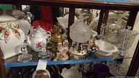 Photo showing Royal Albert cookie jar, teapots, glassware, decorative containers and figurines on shelf