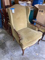 Vintage Fogle Furniture armchair in green corduroy upholstery and carved wooden frame, shown fully assembled with seat cushion and claw feet visible.