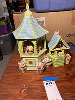Front and side view of Waterford pagoda-shaped cookie jar with blue roof and green bamboo-like pillars and floral decorations.