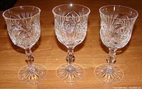 Front view of three Eleanor crystal water/wine goblets showing pinwheel and fan cut patterns.