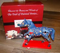 Trail of Painted Ponies figurine and original box showing the decorated blue horse on red base