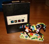 Front view of the Trail of Painted Ponies figurine 'Children of the Garden' next to original black box.