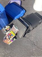 Collection of CD cases and CDs displayed alongside a blue plastic tub and additional carrying case.