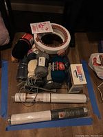 Knitting yarns, knitting machine or loom, wallpaper rolls laid on floor