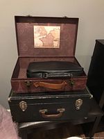 Open carrying case with vintage map design containing a black MahJong set bag.